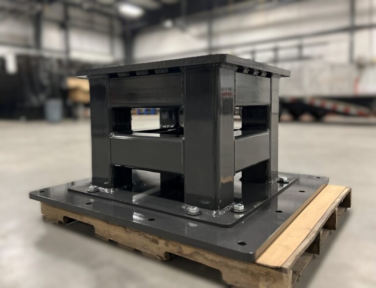 Custom black robot pedestal on a manufacturing floor